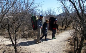 Rock climbers setting out with their crash pads